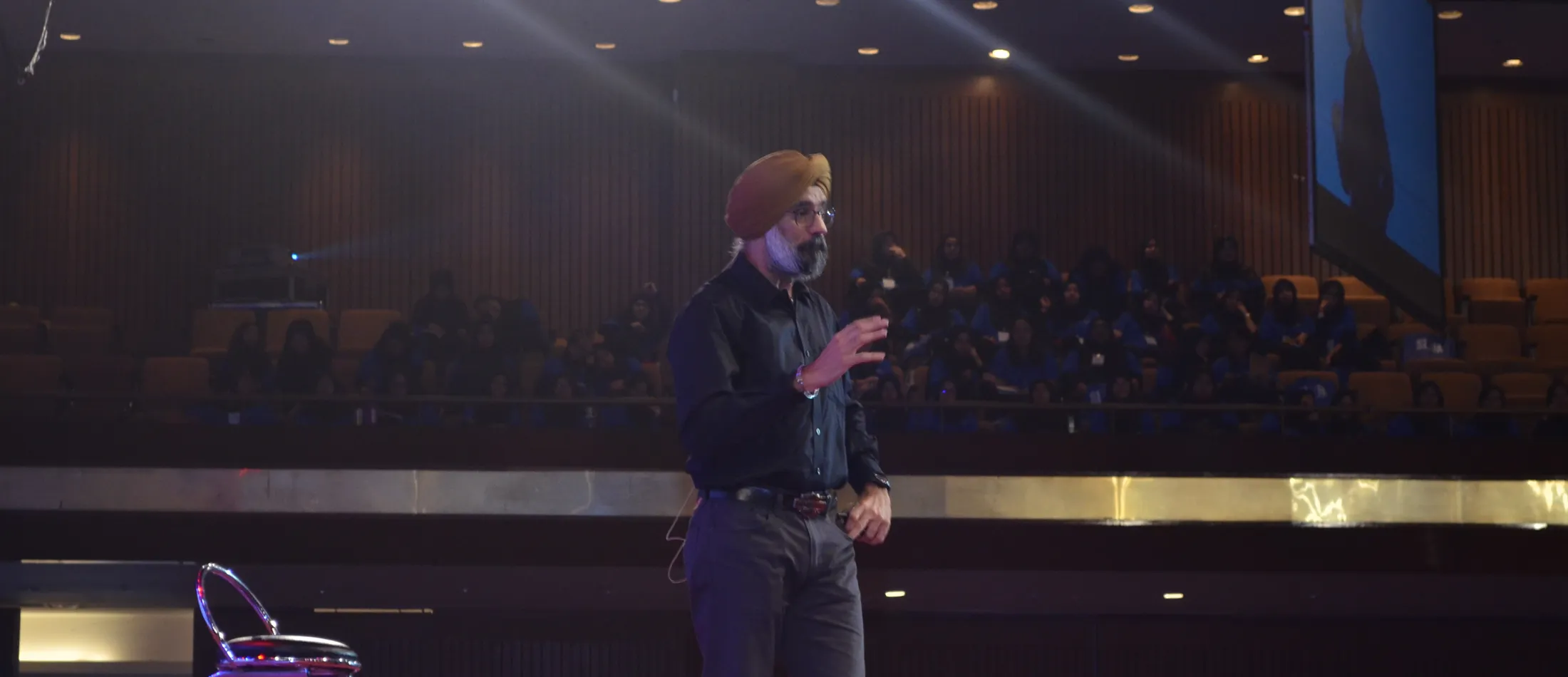A leadership development participant presenting on stage during a live programme session